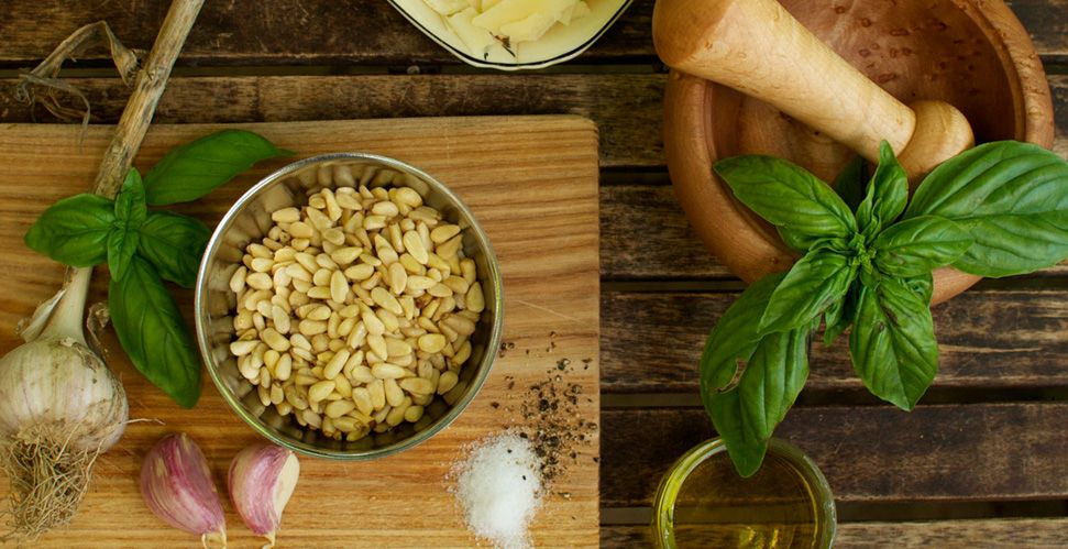 Ingredients for a pesto sauce on a wooden table.